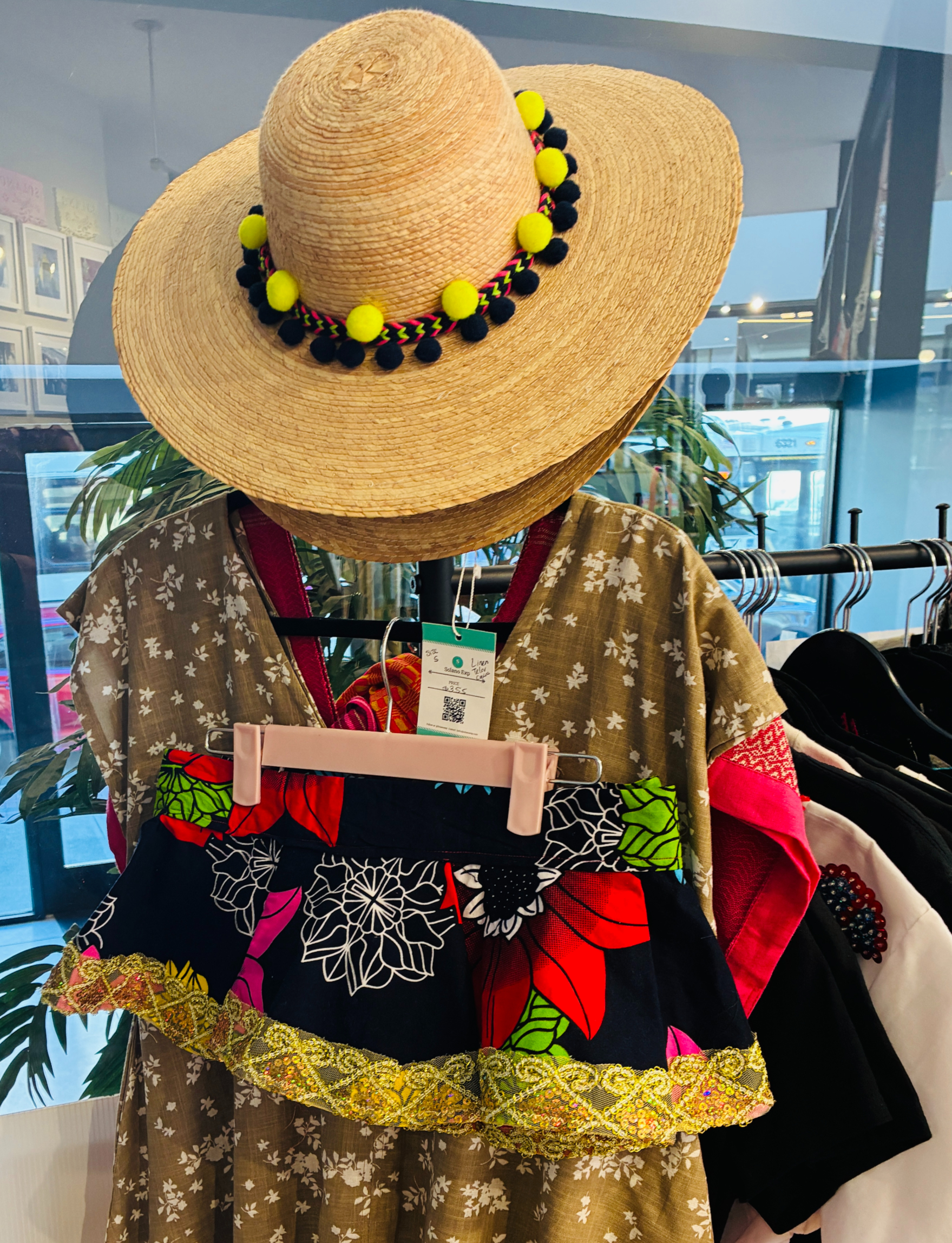 Eye-level view of a colorful peplum top hanging on a clothing rack